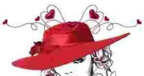 person wearing a red wide brimmed hat with red hearts on the hat 