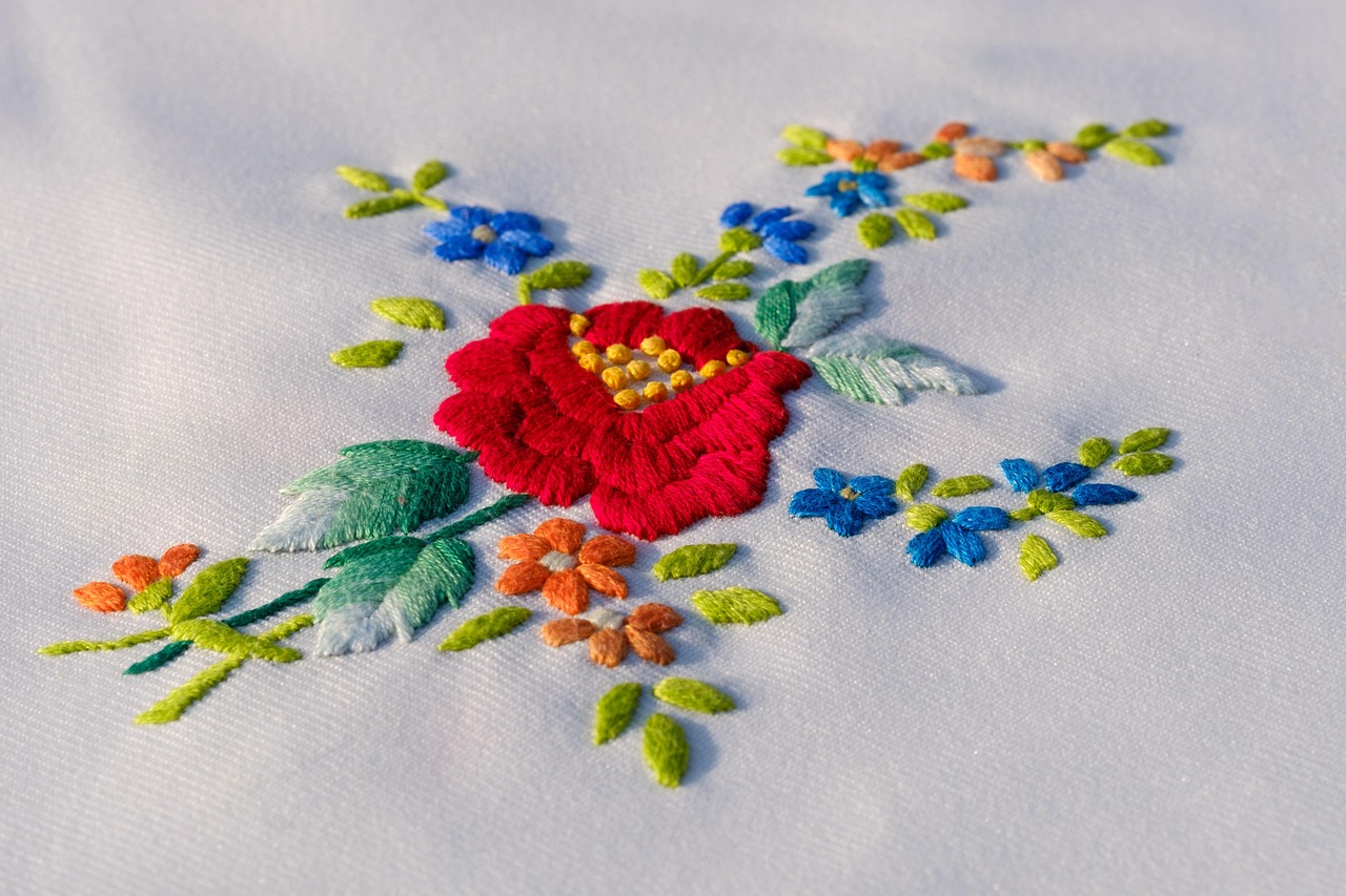 White cloth with an embroider of a flower and leaves.