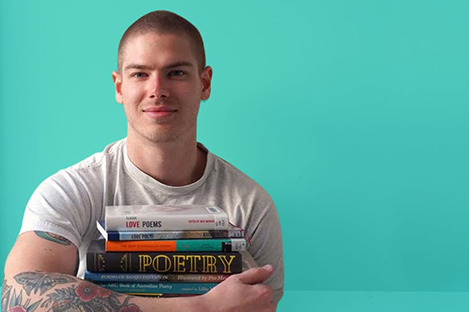 Man holding a stack of poetry books.