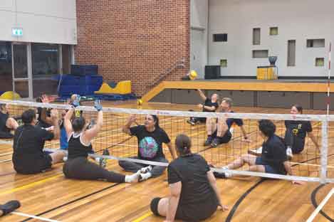 people sitting down playing volleyball
