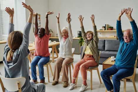 Group of people sitting on chairs stretching