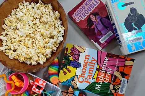 popcorn, books and games on a table